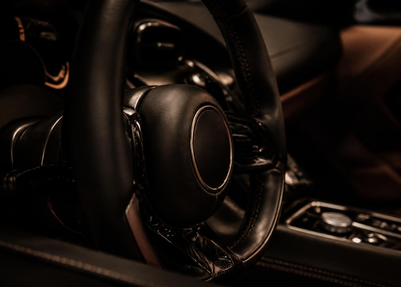 Detail of a supercar steering wheel and cabin